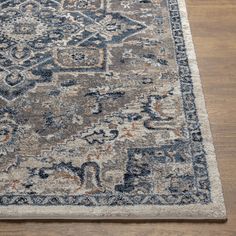 an area rug with blue, orange and beige colors on the wooden floor next to a hardwood floor