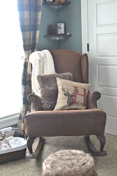 a rocking chair with pillows and blankets on it in front of a white door, next to a window