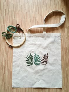 a white bag sitting on top of a wooden floor next to a pair of scissors