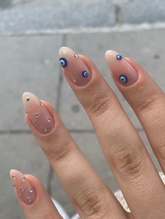 a woman's hand with some blue and white nail designs on it, including an eyeball