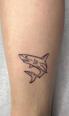 a small shark tattoo on the leg