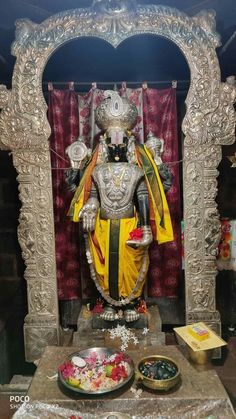 a statue of the god person in front of a shrine with other items around it