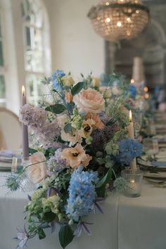 the table is set with flowers and candles