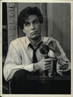 an old black and white photo of a man holding a camera in front of his face