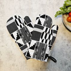 a pair of oven mitts sitting on top of a table next to tomatoes and lettuce