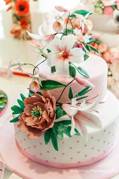 a three tiered cake with flowers on top