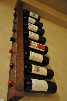 a wooden wine rack with six bottles of wine on it and one shelf holding several bottles