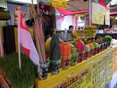 the food stand has many different types of vegetables on display for sale in front of it