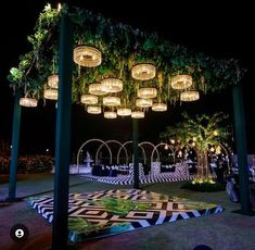 an outdoor wedding venue with lights and greenery on the ceiling, surrounded by black and white checkered flooring