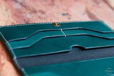 a green wallet sitting on top of a wooden table