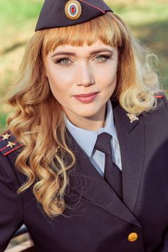 a woman in uniform is posing for a photo with her hair pulled back and bangs down