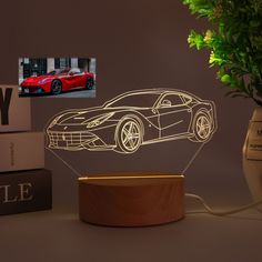 a car is shown in the shape of a lamp on a table next to some books