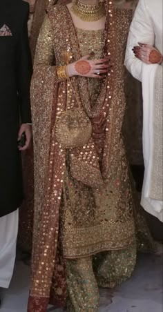 a woman in a gold and red bridal outfit