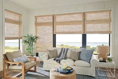 a living room filled with furniture and windows covered in shades of natural bamboo blind blinds