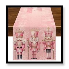 a pink table cloth with three nutcrackers on it