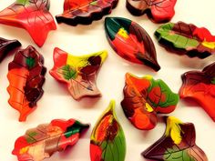 colorful glass leaves are arranged on a white surface