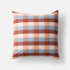 an orange and blue plaid pillow on a white background