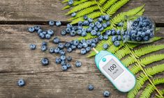 a digital thermometer sitting on top of a wooden table next to blueberries