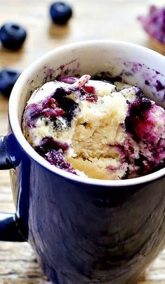 a blueberry muffin in a mug on a table