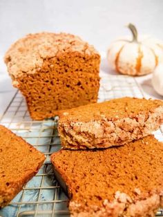 several pieces of bread sitting on top of a cooling rack next to some pumpkins