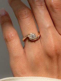 a woman's hand with a diamond ring on top of her finger and the other hand holding it