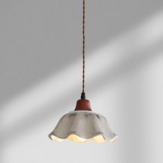 a light that is hanging from a ceiling in a room with white walls and flooring