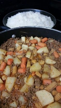 the food is being prepared in the skillet on the stove with rice and carrots