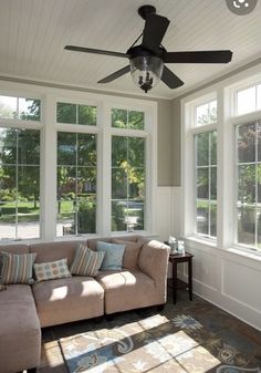 a living room filled with furniture and lots of windows