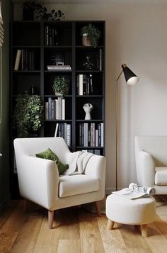 a living room with white furniture and bookshelves