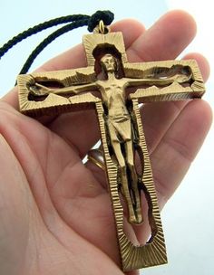 a hand holding a gold colored crucifix