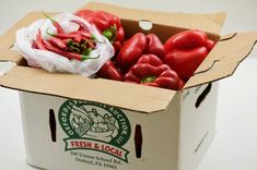 a box filled with red peppers sitting on top of a table