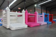 an inflatable bounce house with pink, blue, and white bounquets