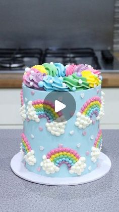 a blue cake with rainbows and clouds on it