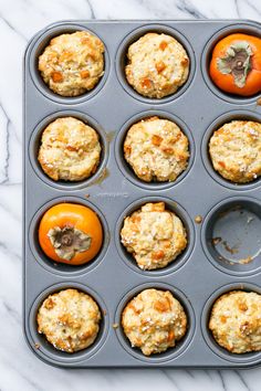 muffins in a muffin tin with oranges on the side