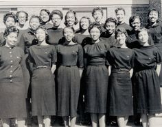 a group of women standing next to each other in front of a building