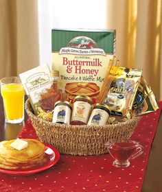 a basket filled with food sitting on top of a table next to a glass of orange juice