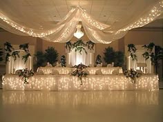 an image of a banquet room setting with lights on the ceiling and white drapes