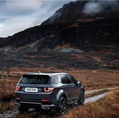 an suv driving down a dirt road in the mountains