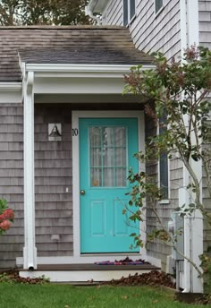 a blue front door on a gray house