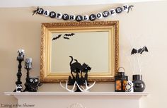 a mantle decorated with black and white halloween decorations