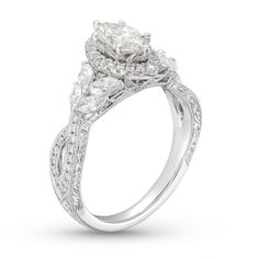 a white gold engagement ring with three pear shaped diamonds on the sides and an intricate band