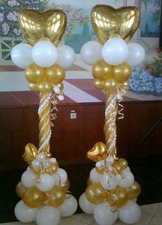 two gold and white balloons are on display