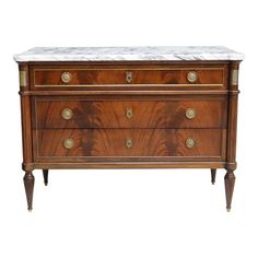 an antique chest with marble top and brass pulls on the bottom, against a white background