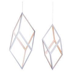 two metal geometric shapes hanging from strings on a white background, one is made out of wood