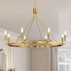 a gold chandelier with six lights hanging from the ceiling in a living room