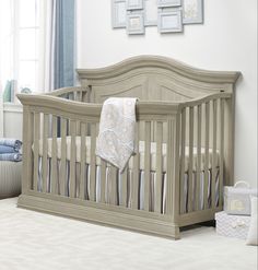 a baby crib in a white room with blue and gray decor on the walls