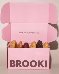 a pink box filled with cookies sitting on top of a table