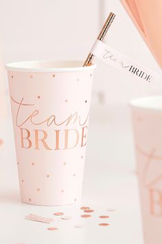 a paper cup with the word team bride written on it and a straw sticking out of it