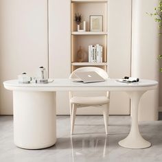 a white table with two chairs and a laptop on it in front of a bookshelf