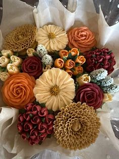 a bouquet of flowers sitting on top of a white tissue paper wrapped in plastic wrap